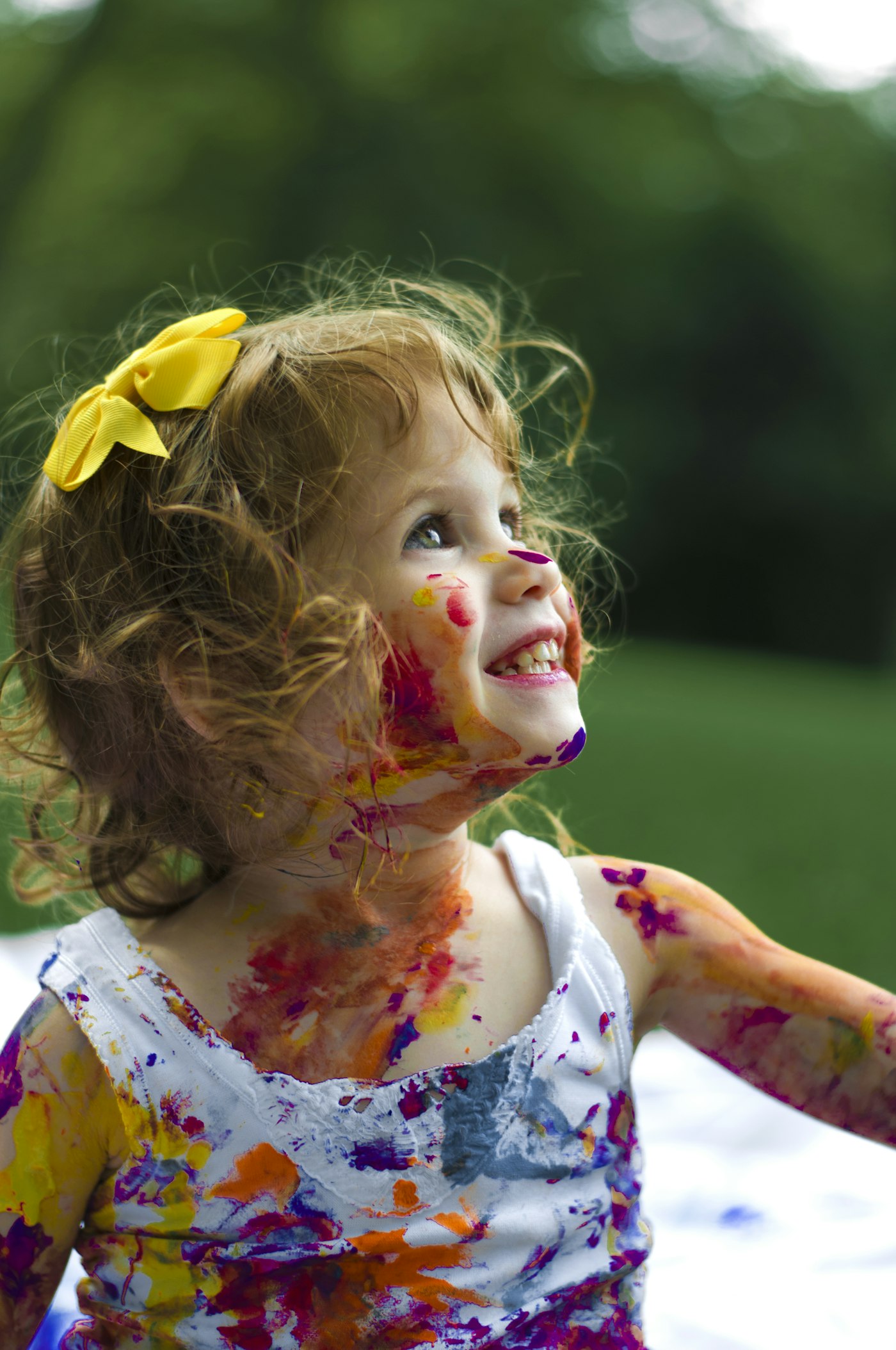 A child playing happily, covered in paint